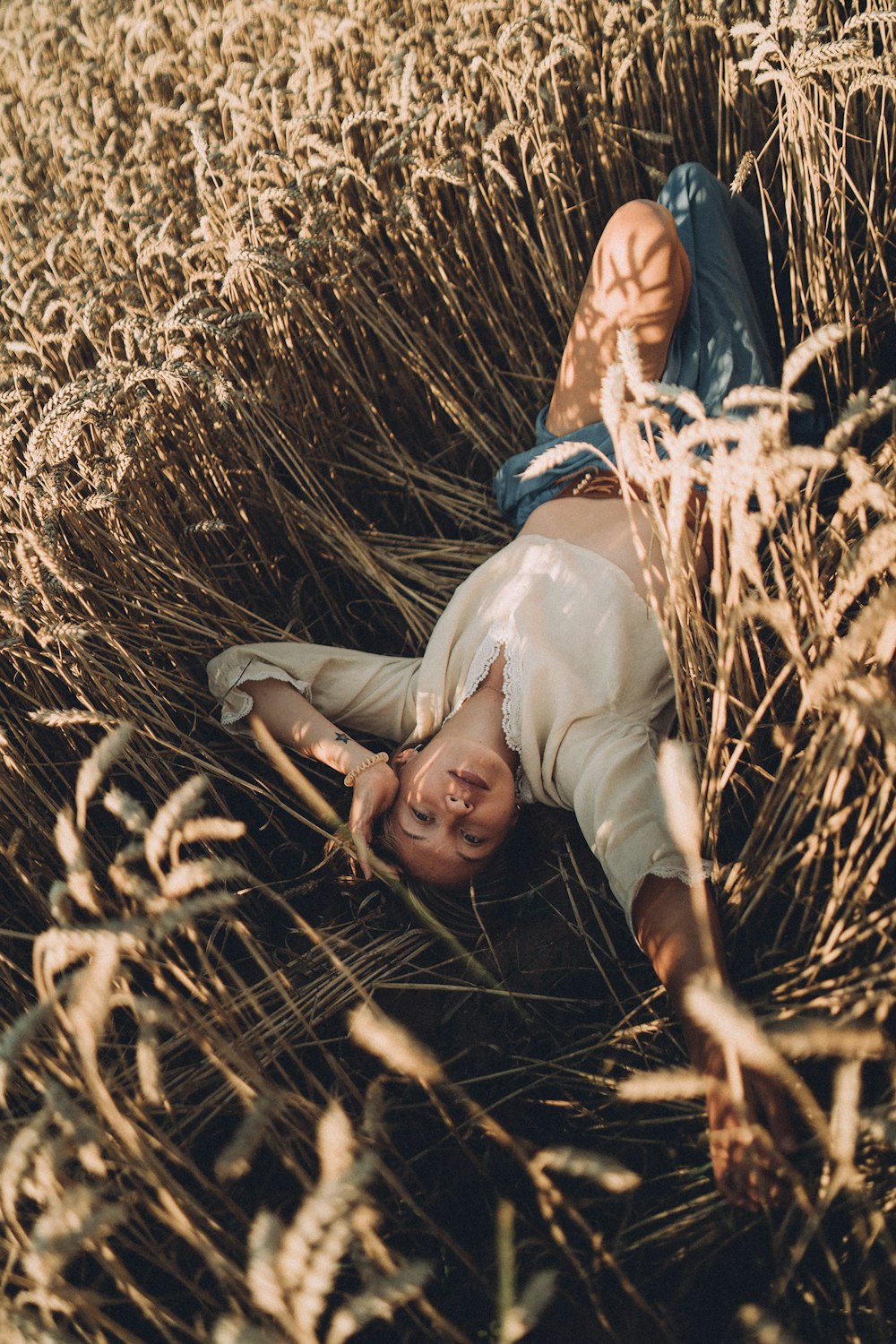 a person laying in a field of tall grass