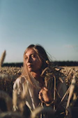 A serene depiction of a maiden holding a sheaf of wheat under a starry night sky.