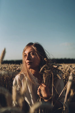 A serene depiction of a maiden holding a sheaf of wheat under a starry night sky.