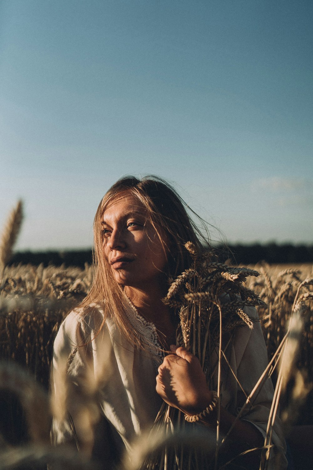 a woman standing in a field of wheat