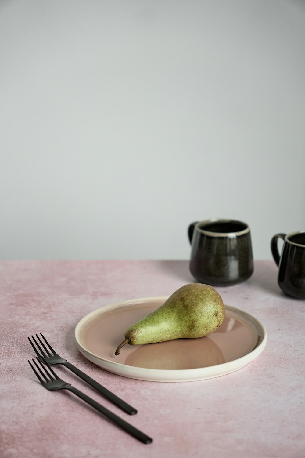 a plate with a pear and a fork on it