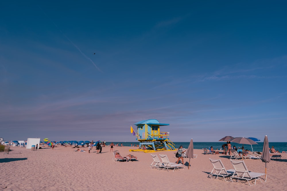 a group of people sitting on top of a sandy beach