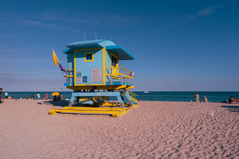 a blue and yellow lifeguard tower on a beach