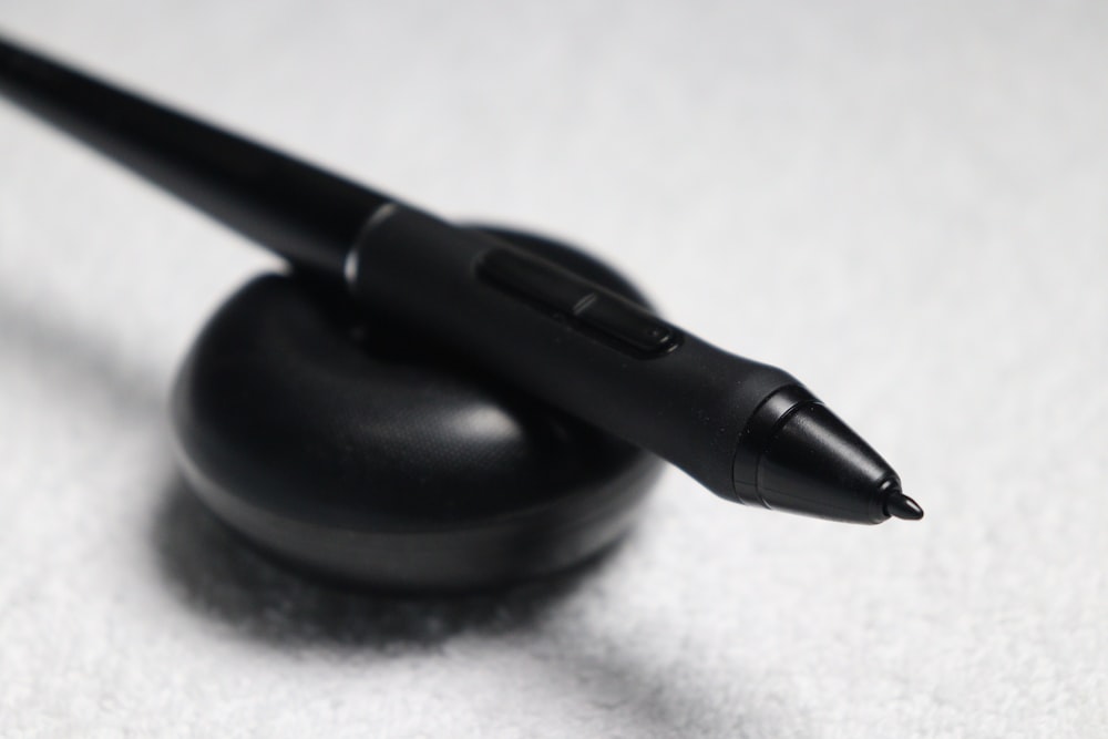 uma caneta preta sentada em cima de um objeto preto