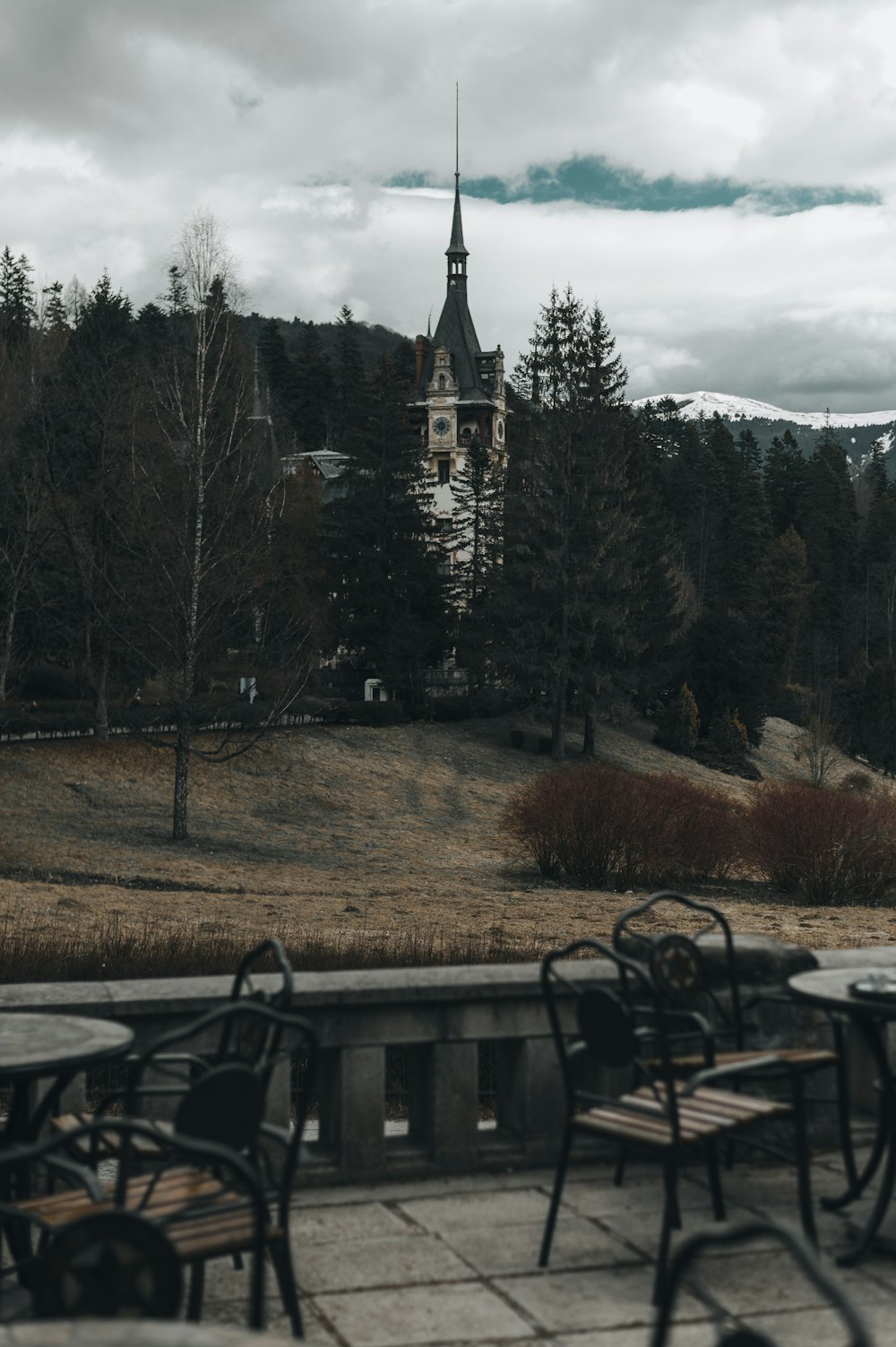 a table and chairs sitting on a patio with a church in the background