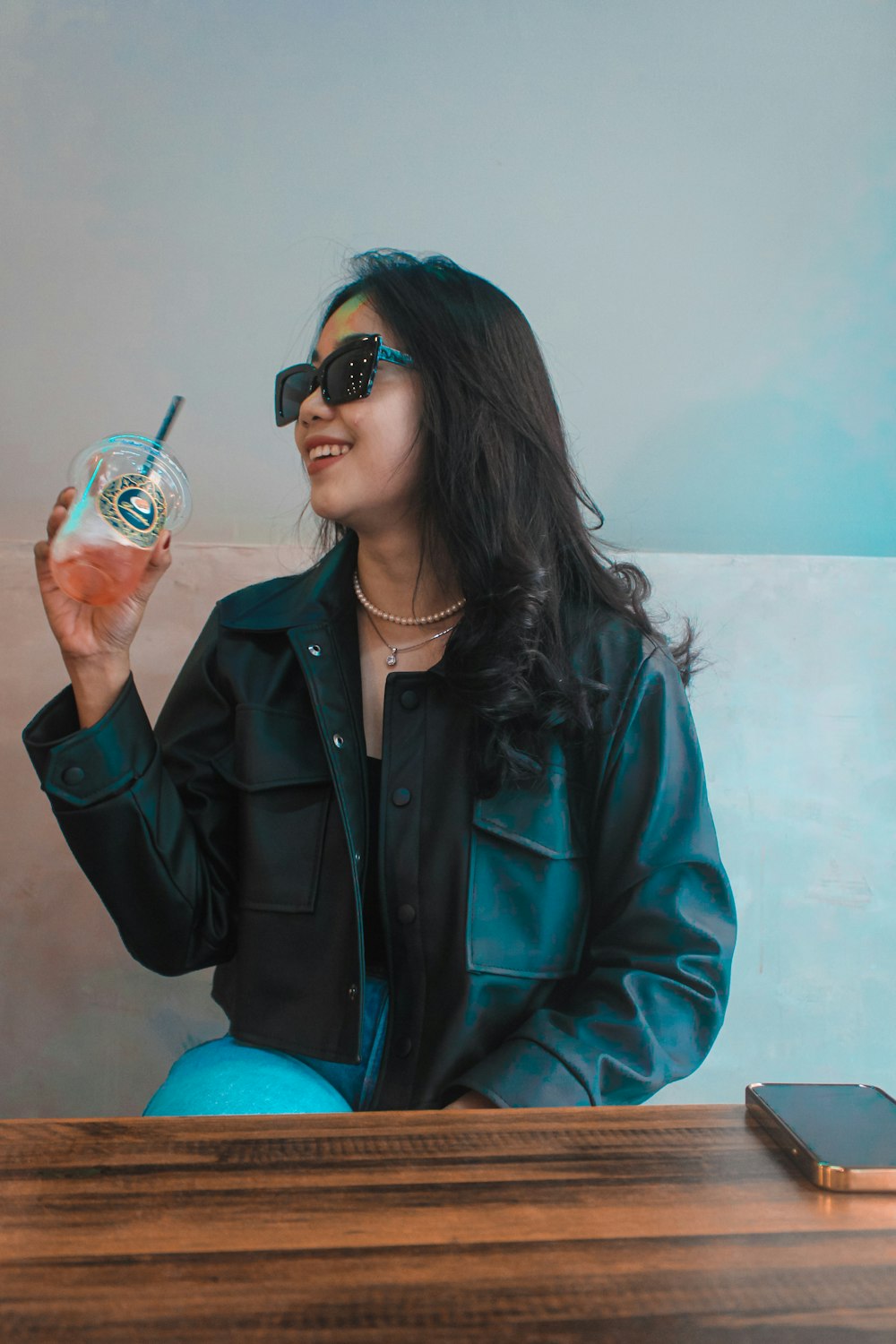 a woman sitting on a table with a drink in her hand