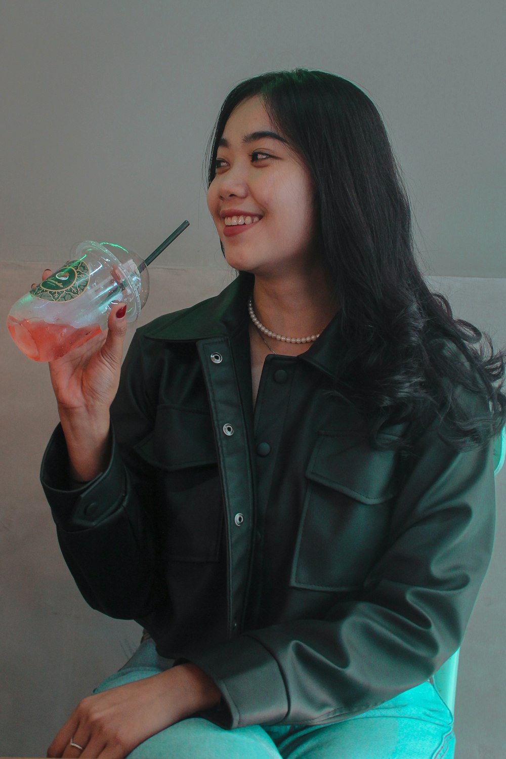 a woman sitting on a chair holding a drink