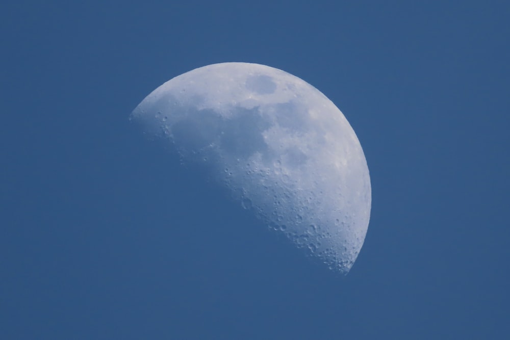 a half moon in a clear blue sky