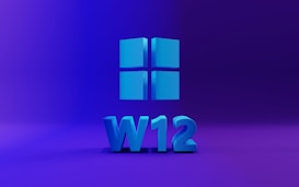 A 3D representation of a Windows logo comprised of four blue squares is centered against a purple gradient background. Below the logo, the characters 'W12' are displayed in the same blue hue, suggesting a version or concept related to Windows.