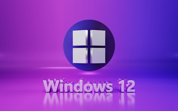 A 3D representation of the Windows logo is prominently displayed against a vibrant purple background. Below the logo, the text 'Windows 12' is written in a matching shade, with a modern and sleek typography. The overall image has a futuristic and digital aesthetic.