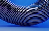 A series of sleek, metallic, black curved lines arranged in a wave-like pattern against a smooth blue background. The reflections on the metallic surface add a glossy and futuristic feel.