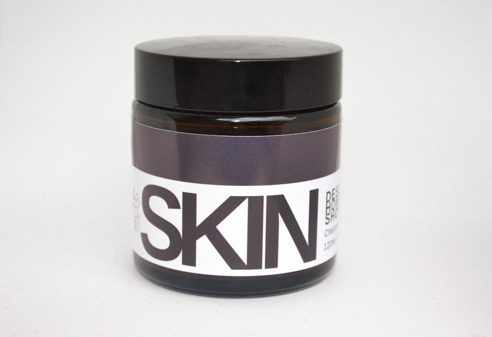 a jar of skin paste sitting on a white surface