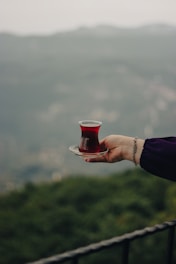 a person holding a plate with a cup on it