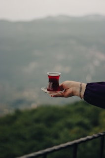 a person holding a plate with a cup on it