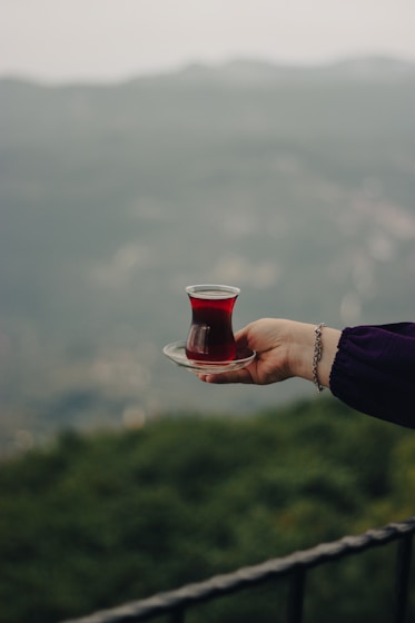 a person holding a plate with a cup on it