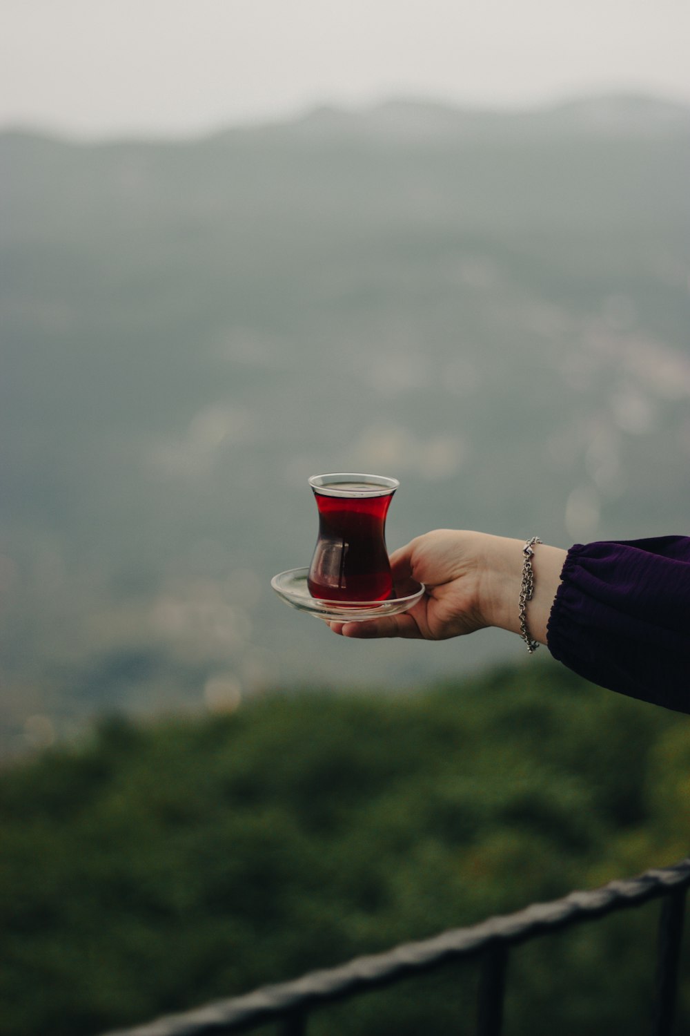 a person holding a plate with a cup on it