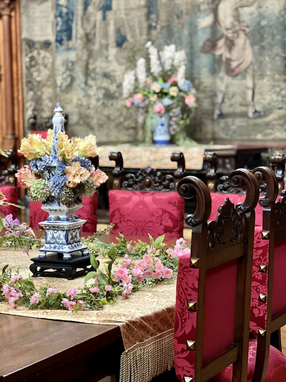 a dining room table with a vase of flowers on it