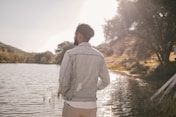 a man standing next to a body of water