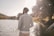 a man standing next to a body of water