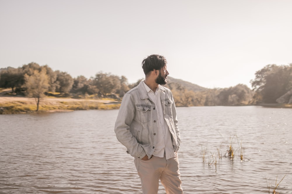 a man standing in front of a body of water