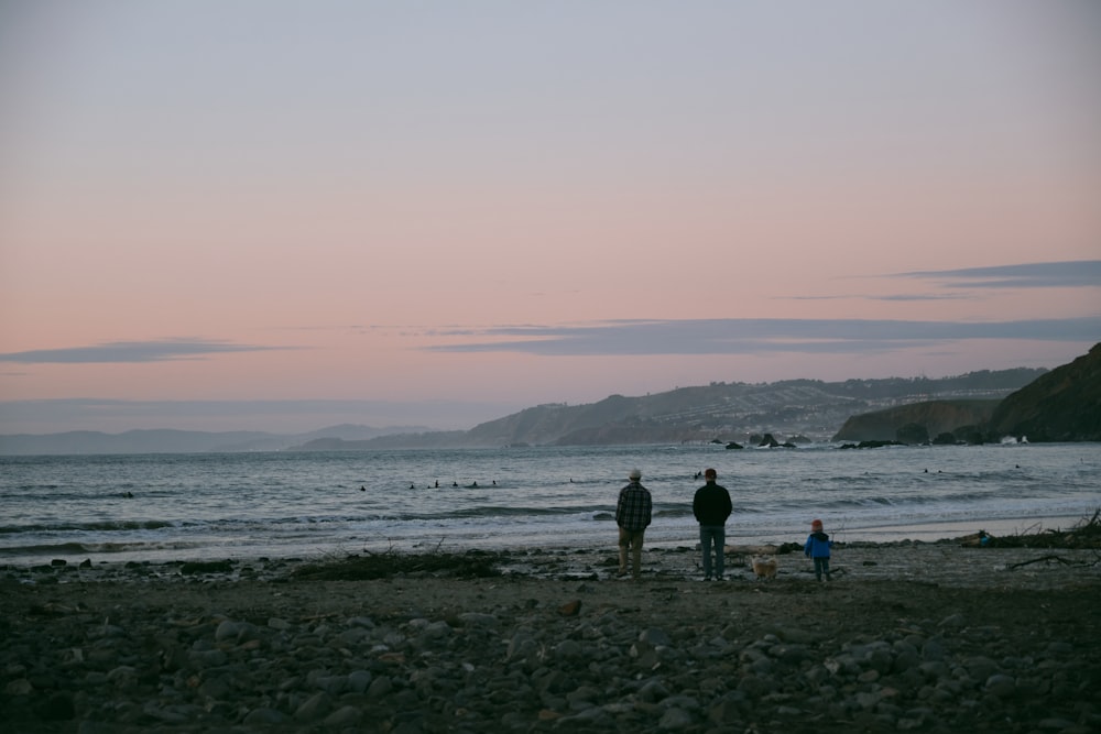 a couple of people standing on top of a beach