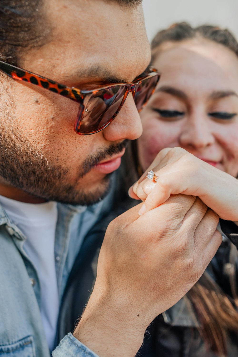 a man putting a ring on a woman's finger