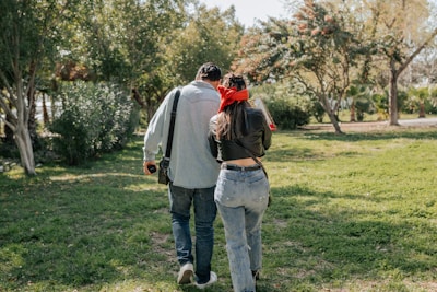 a man and a woman walking in the grass