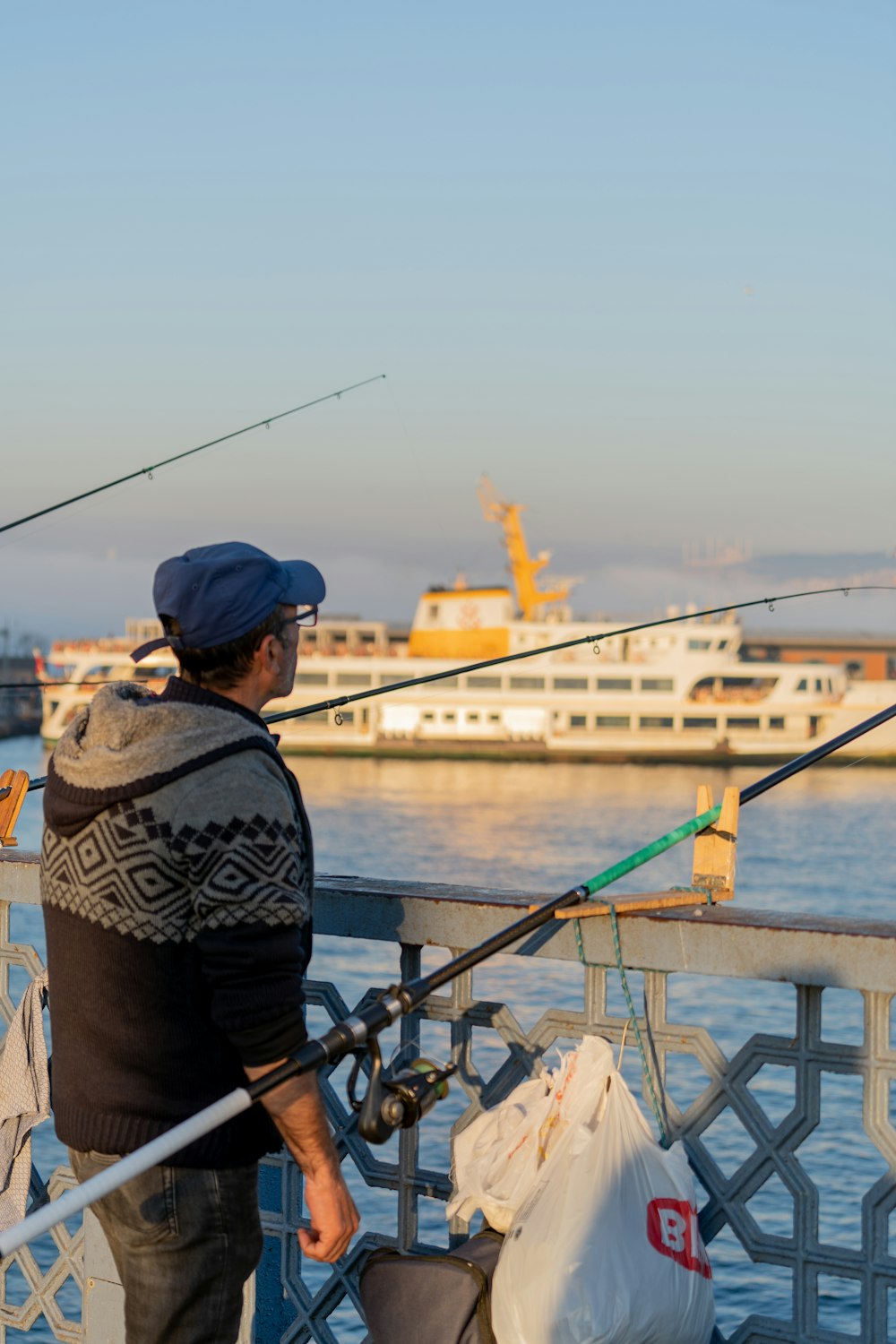 A man standing on a pier holding a fishing rod photo – Free Passenger ship  Image on Unsplash