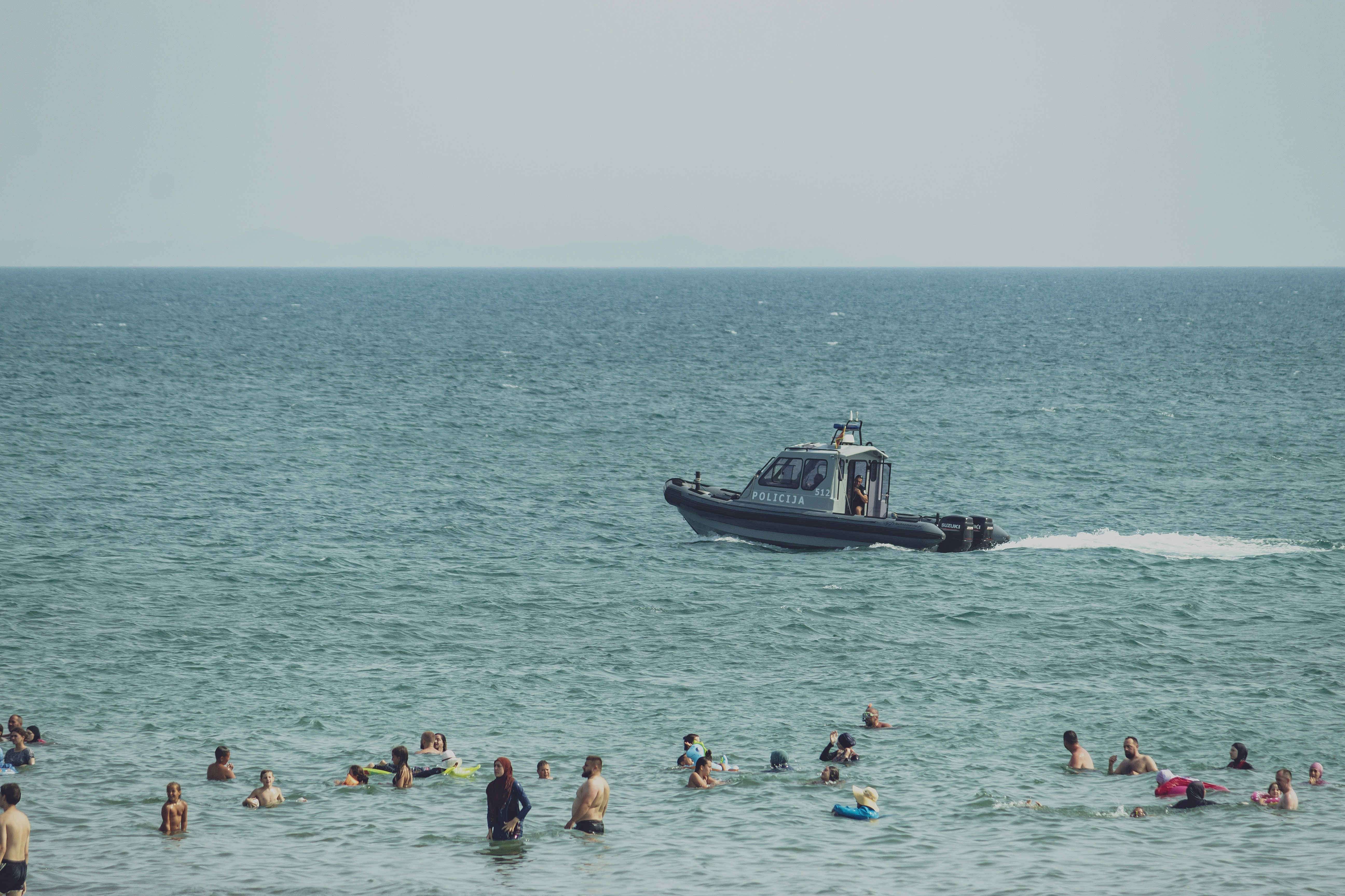 a boat in the ocean with a lot of people swimming around