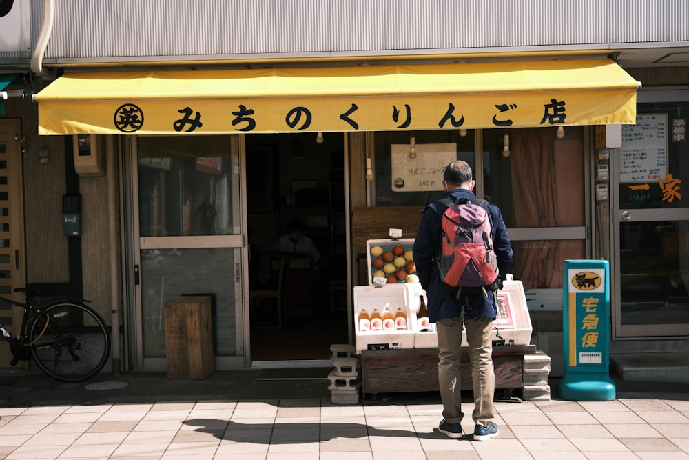 uma pessoa com uma mochila em pé na frente de uma loja