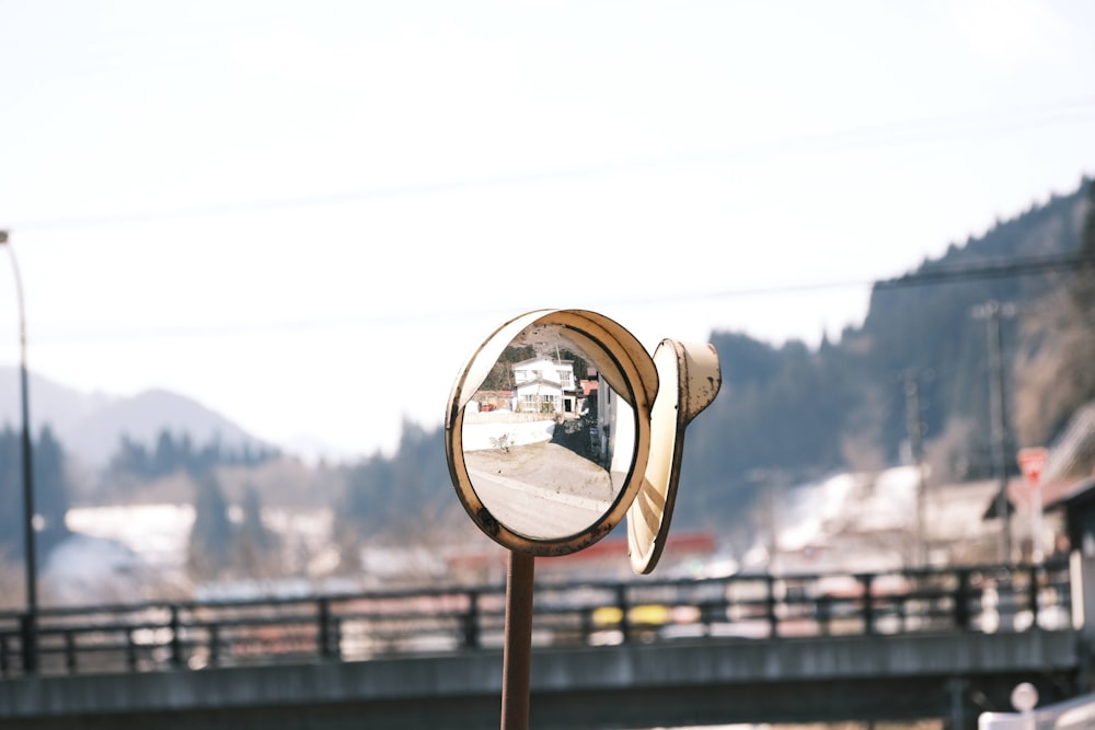 a close up of a parking meter with a bridge in the background