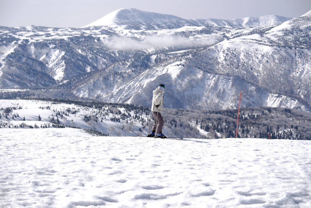 a person standing on top of a snow covered slope