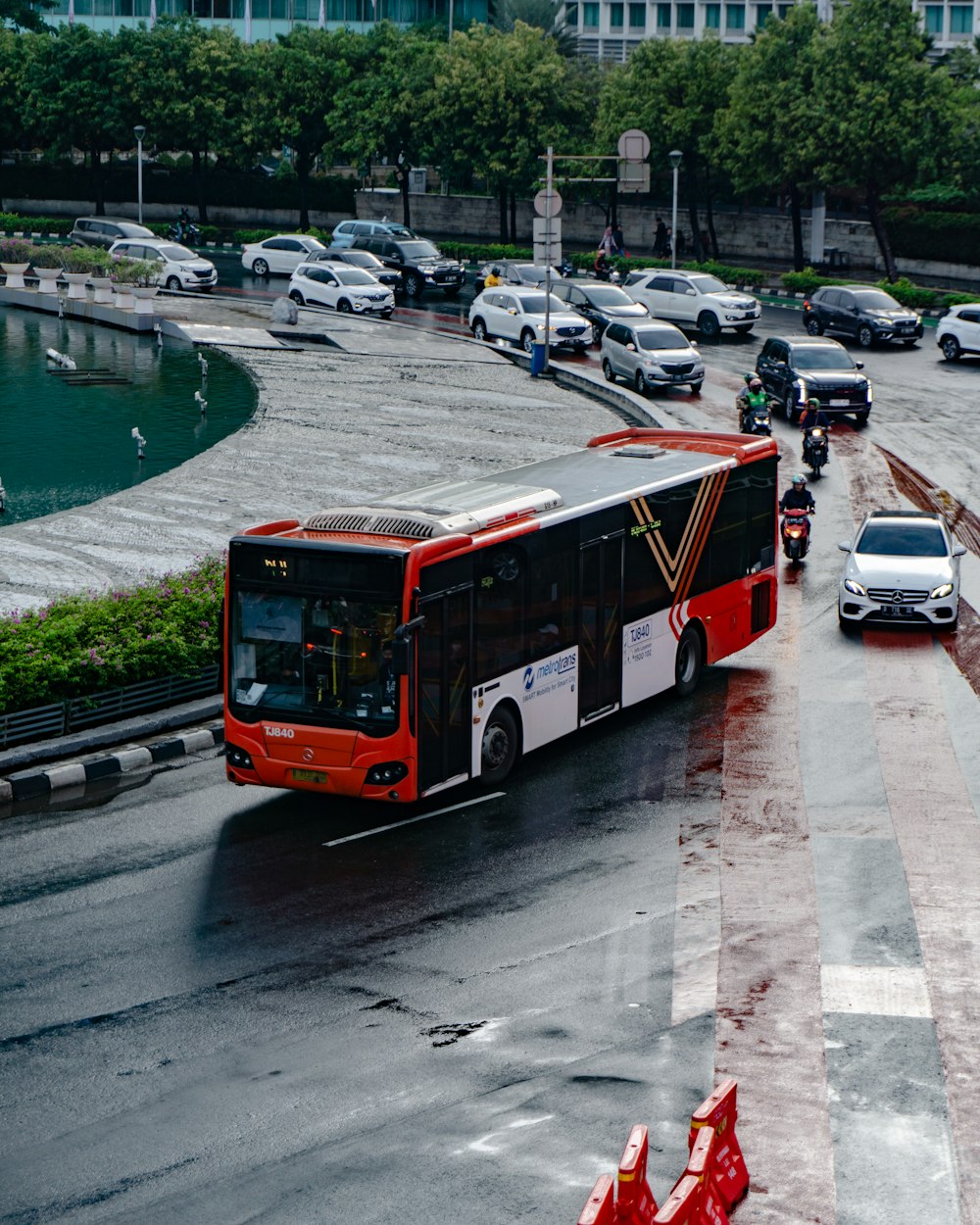 a red and white bus driving down a street
