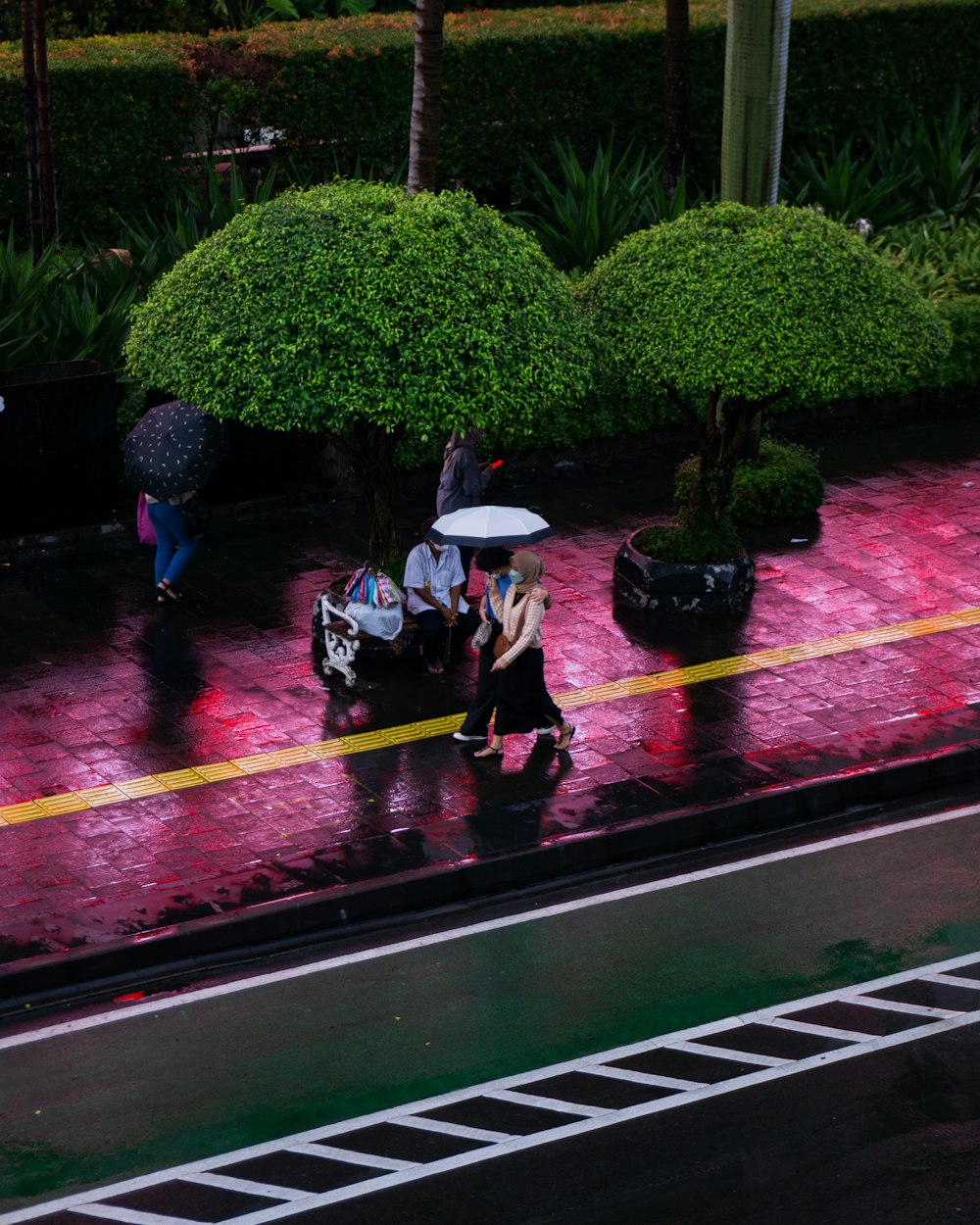 a group of people walking down a street holding umbrellas