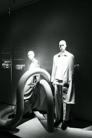 A sleek display of modern fashion apparel on minimalist mannequins.