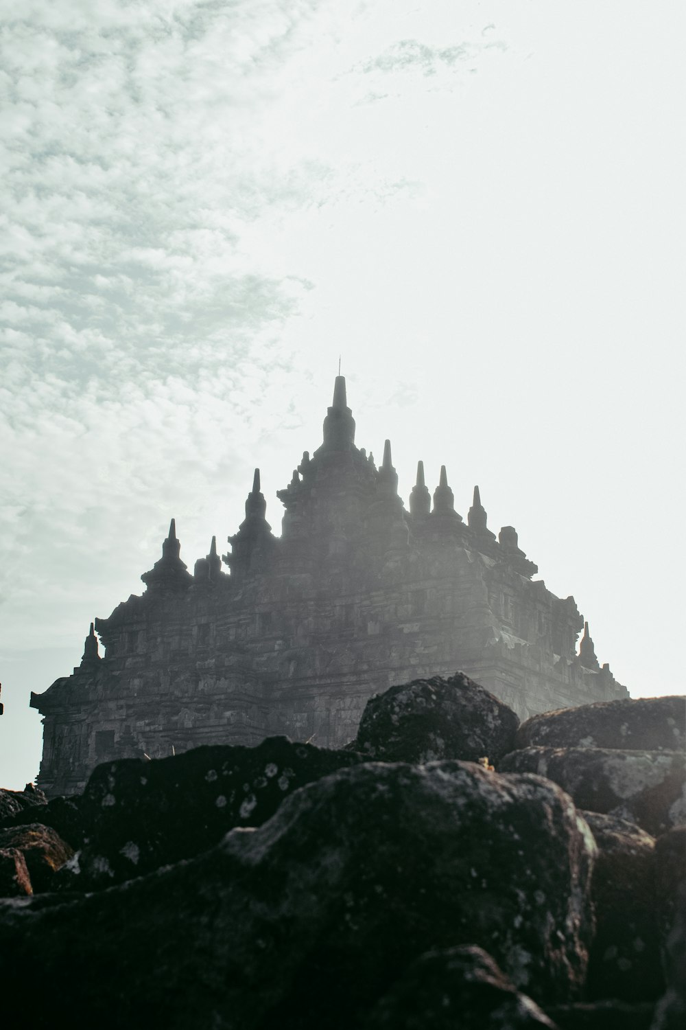 a very tall building sitting on top of a rocky hill