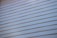 A close-up view of a light-colored wooden wall with horizontal siding, where each plank is neatly aligned and evenly spaced.