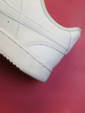 Close-up of a sleek women's leather sneaker on a neutral background.