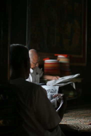 A cheerful senior couple enjoying a sunny afternoon reading a magazine together in their cozy living room.