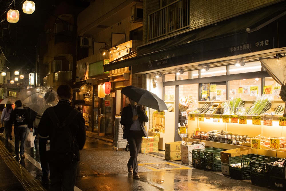 a group of people walking down a street holding umbrellas