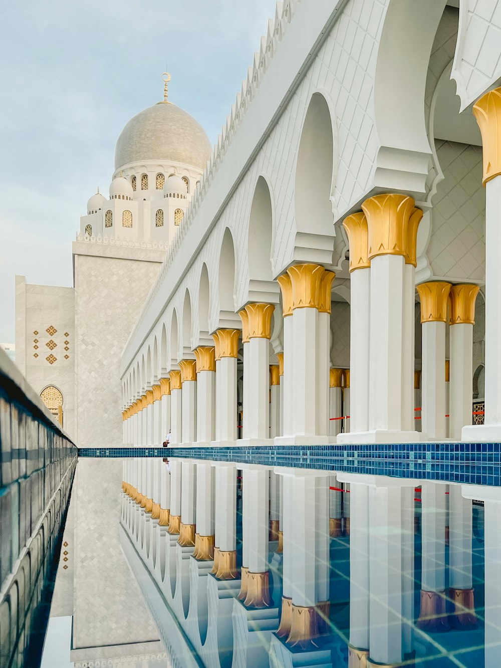 a large white building with a pool in front of it