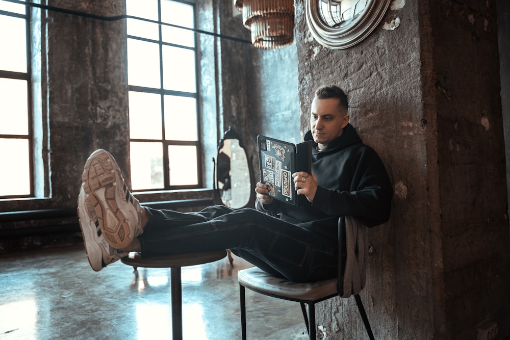 a man sitting in a chair reading a book