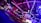 An indoor arena with vibrant purple and blue lighting, featuring large numbered screens suspended from the ceiling. The venue has a high ceiling with intricate metal truss structures and hanging lights, creating a futuristic and energetic atmosphere.