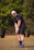 A golfer wearing a sleek, breathable polo shirt standing on a sunny golf course.