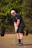 A golfer wearing a sleek, breathable polo shirt standing on a sunny golf course.