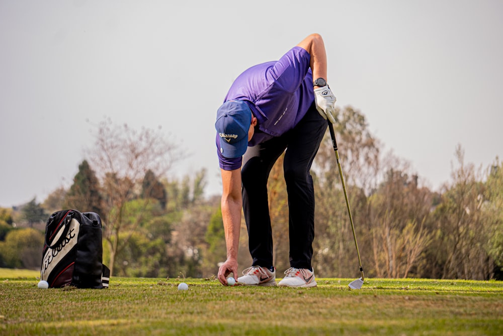 a man putting golf balls on the ground