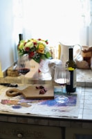 A cozy kitchen scene with hands slicing creamy cheese and a glass of wine nearby.