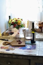 a table with a bottle of wine and two glasses of wine