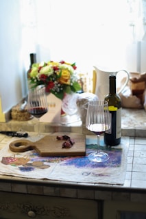 A cozy kitchen scene with a bottle of red wine and two glasses ready for pouring.