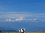 A spacious white SUV ready for a family trip on a mountain trail.
